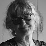 Woman with glasses smiles at the camera